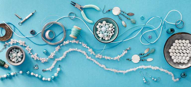 Creative flat lay, panoramic composition. DIY craft hobby. Making handmade jewelry for friends as Christmas gifts. Flat lay on mint color background.